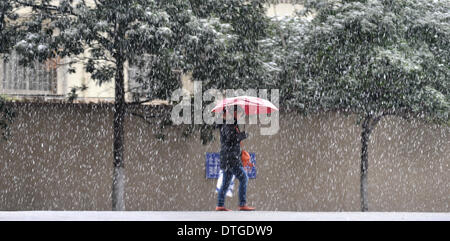 Changsha, provincia cinese di Hunan. 18 Febbraio, 2014. Una donna cammina nella neve in Changsha, capitale della centrale provincia cinese di Hunan, Feb 18, 2014. Credito: lunga Hongtao/Xinhua/Alamy Live News Foto Stock
