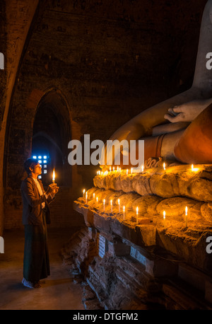 BAGAN, MYANMAR - CIRCA NEL DICEMBRE 2013: Pellegrino pagando tributo a Buda nel Pahto Thamya tempio di Bagan Foto Stock