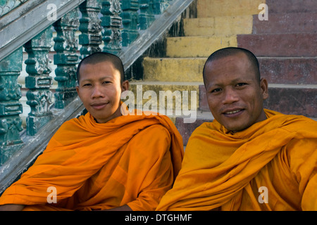 Due monaci buddisti indossando safron arancione vesti stanno godendo la loro giornata in un tempio buddista in Stung Treng Cambogia. Foto Stock