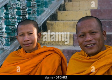 Due monaci buddisti indossando safron arancione vesti stanno godendo la loro giornata in un tempio buddista in Stung Treng Cambogia. Foto Stock