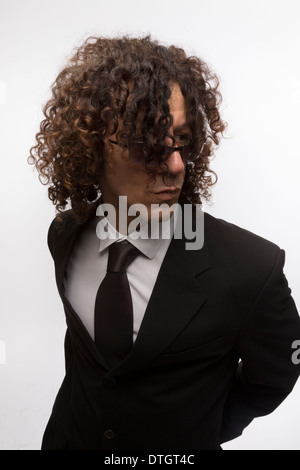 Ritagliato ritratto del mediterraneo cerca uomo con capelli ricci indossando business suit e occhiali da sole Foto Stock