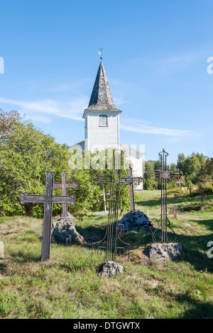 Il vecchio metallo arrugginito attraversa nel cimitero e chiesa bianca in background. La foto è stata scattata in Isola di Keri in Estonia. Foto Stock