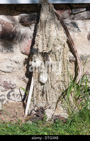 Divertente faccia di pietre bianche e la vecchia rete da pesca Foto Stock