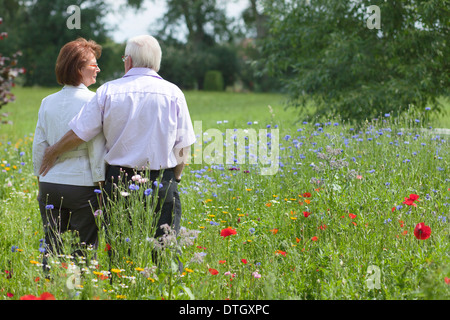 Coppia senior in piedi su un prato di fiori, Bassa Sassonia, Germania Foto Stock