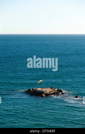 Isola artificiale realizzato ​​of blocchi in calcestruzzo con il rosso e bianco striato indicatore del vento nel Mediterraneo al largo delle coste spagnole Foto Stock