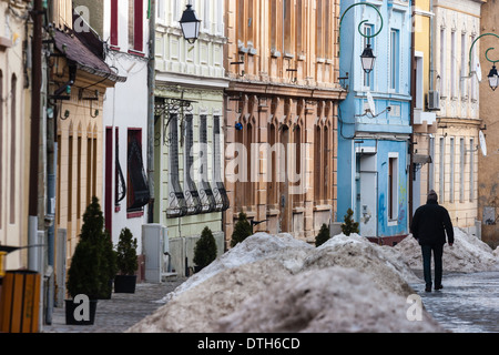 Uomo che cammina sulla strada stretta con case colorate Foto Stock