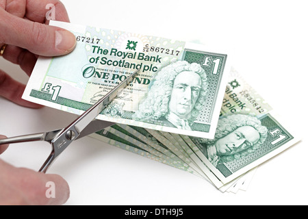 Taglio di una nota scozzese di una sterlina con un paio di forbici, Scozia, Regno Unito Foto Stock