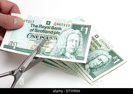 Taglio di una nota scozzese di una sterlina con un paio di forbici, Scozia, Regno Unito Foto Stock