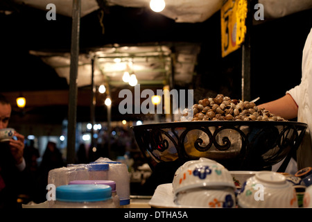 L'uomo vendita di lumache al mercato alimentare di Marrakech, Marocco Foto Stock
