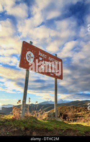Parc Natural de Corse signpost riddled con il cacciatore fori di proiettile contro un Rising Sun Foto Stock