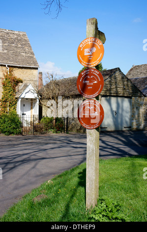 Sentiero pubblico & Bledisloe Cup ' vincitore del miglior conservati Village' segni in Lower Slaughter, Gloucestershire, Inghilterra. Foto Stock