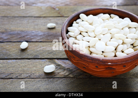 Materie di fagioli bianchi in una ciotola di ceramica, cibo closeup Foto Stock