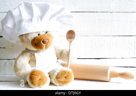 Orsacchiotto di peluche in chef hat con cucchiaio cibo astratto concetto di sfondo Foto Stock