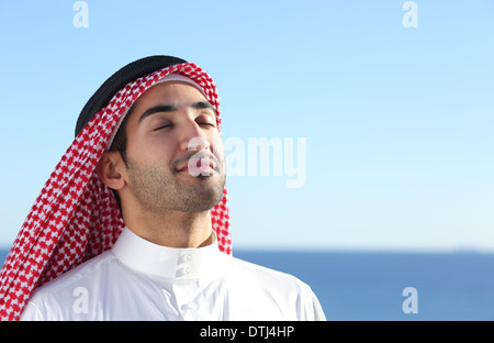 Arab arabia uomo respirazione profonda aria fresca in spiaggia con l'oceano e orizzonte in background Foto Stock