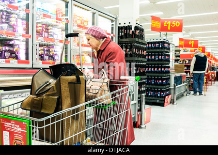 Titolare di una pensione o di una rendita di shopping in un supermercato Asda. Foto Stock