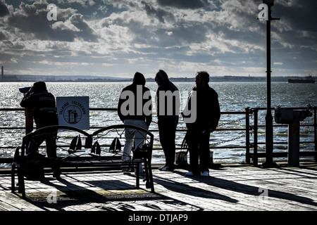 Un gruppo di uomini in piedi sul molo di Southend. Foto Stock