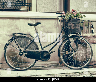 Vintage foto stilizzata della vecchia bicicletta che trasportano fiori come decorazione Foto Stock