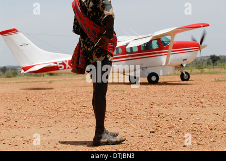 Uganda Karamoja Kotido, popolo Karimojong, pastorale tribù, MAF aereo Cessna a Sandy pista di atterraggio per aerei e Karamojong guerriero con pattini realizzati in cura dal pneumatico Foto Stock