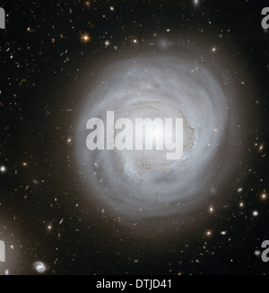 Questo telescopio spaziale Hubble vista mostra la galassia a spirale NGC 4921 lungo con uno spettacolare sfondo di più distanti galassie. Foto Stock