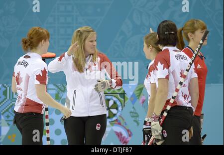 Sochi, Russia. Il 19 febbraio 2014. (L a r) il canadese ragazze celebrare la vittoria. Alba McEwen (CAN, Jennifer Jones (può saltare), Kaitlyn Lawes (CAN, vice skip) e Jill Officer (possibile) come Claire Hamilton (GBR) guarda sconsolato. Womens Curling semi-finale - GBR v può - Ice Cube curling center - Olympic Park - Sochi - Russia - 19/02/2014 Credit: Sport In immagini/Alamy Live News Foto Stock