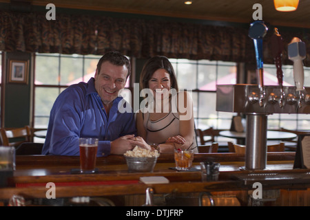 Un uomo e una donna a fianco a fianco seduto in un bar di sorridere su una data nuova speranza in Pennsylvania USA Foto Stock