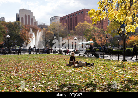 Giovane rilassarsi sul prato in foglie di autunno, Washington Square Park, New York, Stati Uniti d'America Foto Stock