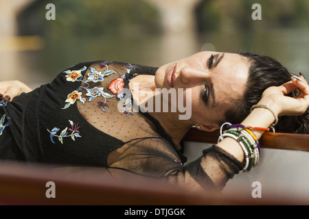Una donna sdraiata sulla schiena, indossando un top nero con maniche a strapiombo e braccialetti di ricamo sul suo braccio Pennsylvania USA Foto Stock