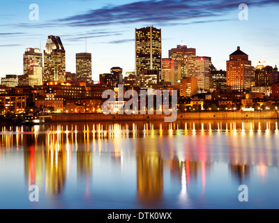 Lo skyline di Montreal al crepuscolo con edifici riflessioni sul fiume San Lorenzo Foto Stock