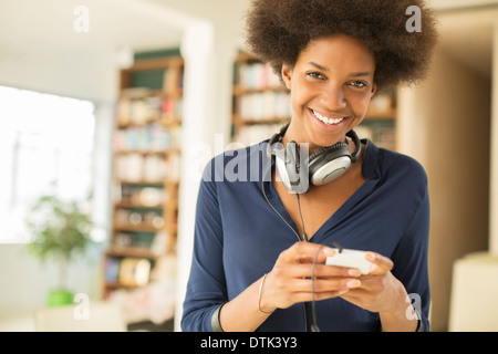 Donna ascoltando le cuffie in salotto Foto Stock