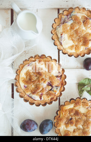 Vista superiore della deliziosa piccola pasticceria crostate con prugne fresche. Foto Stock