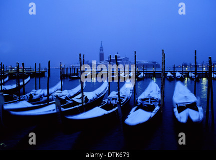 Coperta di neve delle gondole e San Giorgio Maggiore all'alba Molo Venezia Venezia Veneto Italia Foto Stock