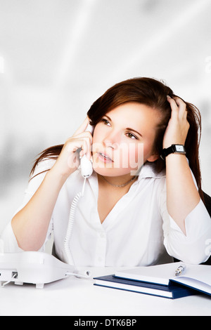 Giovane donna lavora lontano alla sua scrivania Foto Stock