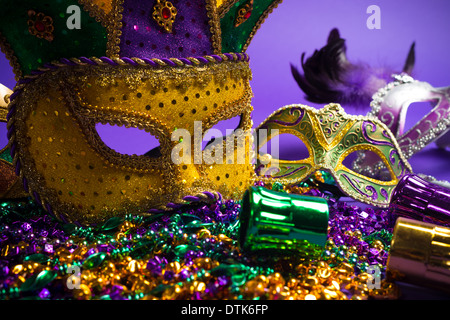 Raggruppamento di festa del Mardi Gras, veneziano o carnivale maschere su uno sfondo viola Foto Stock