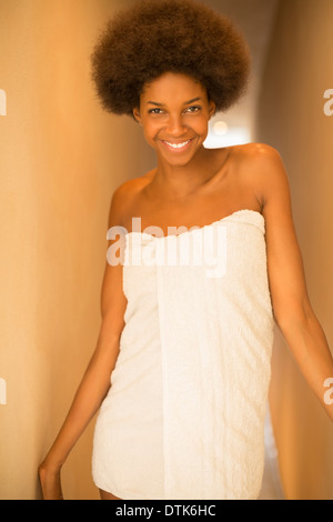Donna sorridente avvolto in un asciugamano Foto Stock