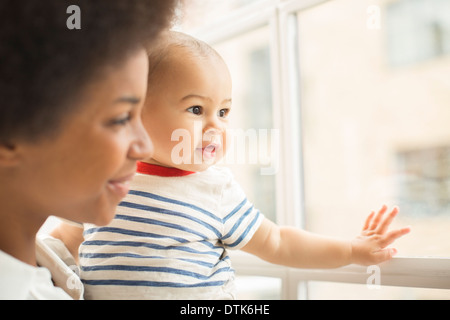 La madre e il bambino a guardare fuori dalla finestra Foto Stock