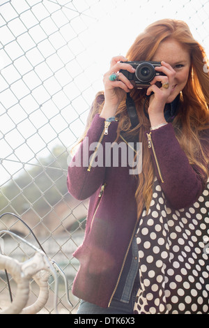 Donna sorridente con la catena collegamento recinto Foto Stock