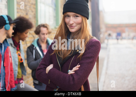 Donna sorridente su una strada di città Foto Stock