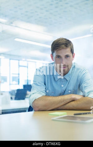 Imprenditore seduto alla scrivania in ufficio Foto Stock