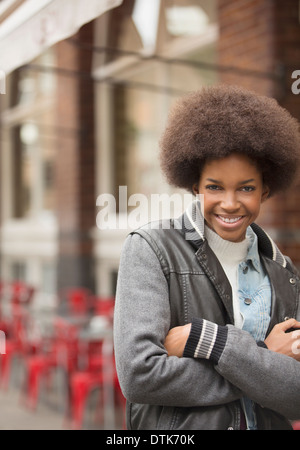 Donna sorridente su una strada di città Foto Stock