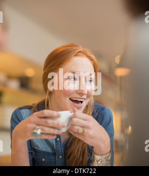 Donna di bere il caffè nella caffetteria Foto Stock