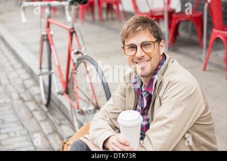 Uomo di bere il caffè sulla strada di città Foto Stock