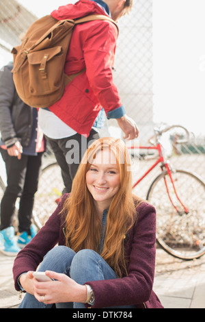 Donna sorridente su una strada di città Foto Stock