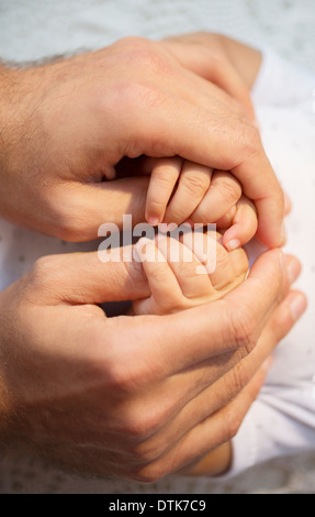 Padre holding baby boy le mani Foto Stock