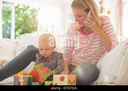 Madre con bambino ragazza parlando al cellulare Foto Stock