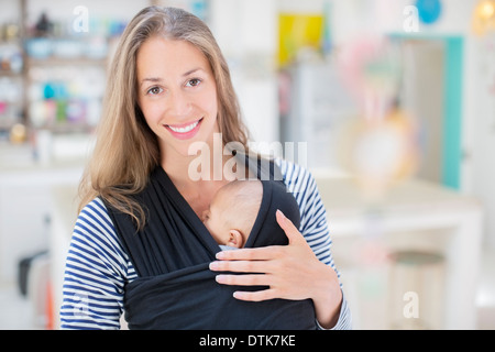 Azienda madre sleeping baby boy in imbracatura Foto Stock