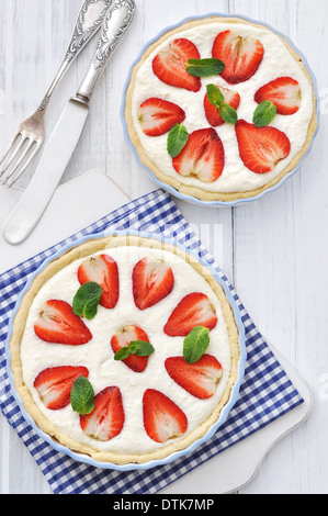 Crostata di fragole con ripieno di ricotta in una teglia su sfondo di legno Foto Stock