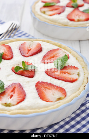 Crostata di fragole con ripieno di ricotta in una teglia su sfondo di legno Foto Stock