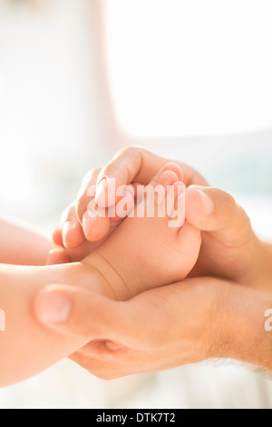Padre cullano baby boy i piedi Foto Stock