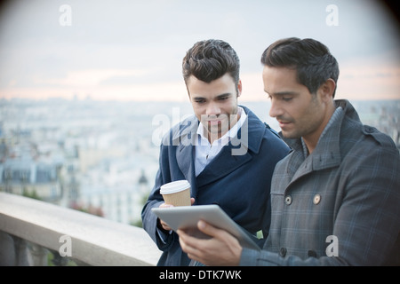 Imprenditori con tavoletta digitale con Parigi, Francia in background Foto Stock