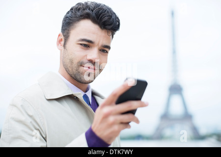 Imprenditore tramite telefono cellulare dalla Torre Eiffel, Parigi, Francia Foto Stock